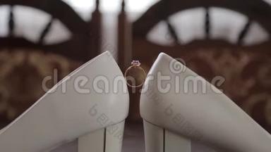 结婚戒指在女人`白鞋上。 新娘白鞋上漂亮`结婚戒指